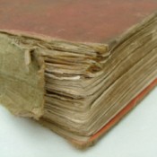A worn and torn binding of a hard cover book.