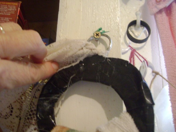 Attaching lace to the ring with it hanging from key ring loop on the wall.