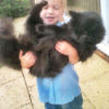 Small girl holding a very large black cat.