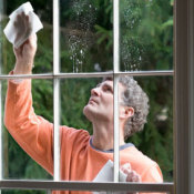 A man cleaning a window in his house.