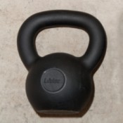 One 26 pound (12 kg) black kettlebell used for exercising.