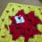 Granny square with bread closure attached, marked with a J.