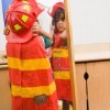 LIttle BOy Looking in the Mirror at his Fire Fighter Costume