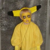 Boy in Pikachu Costume Against Spider Web Curtain Background