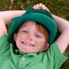 Little Boy Laying in the Grass Dressed as a Leprechaun