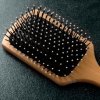 Wooden hairbrush on a black background.