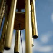 Upclose photo of a wind chime hanging outside.