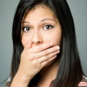 Woman with bad breath covering her mouth.