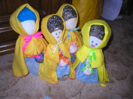 Small dolls with yellow capes made from cloths.