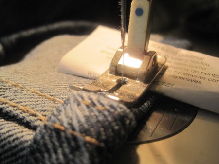 Closeup of folded paper under rear of presser foot.