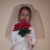 Young girl in a bride costume with red roses.