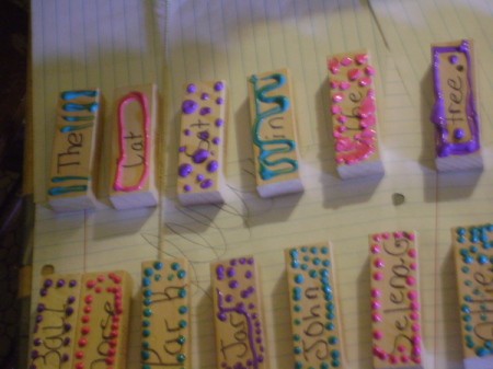 Closeup of decorated Jenga sticks with words added.