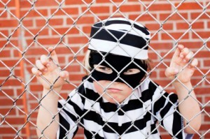 Boy Behind Fence in Convict Costume