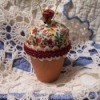 A pincushion made from fabric and a terra cotta pot.