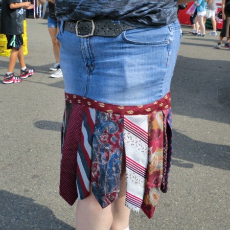 Upclose photo of necktie and denim skirt.