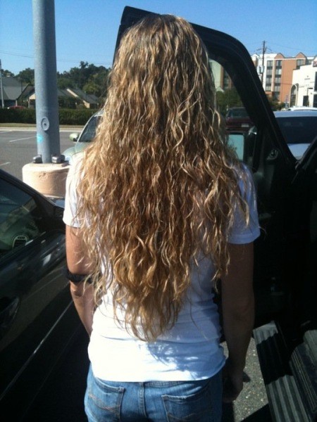 Woman with long curly hair flowing down her back.