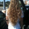 Woman with long curly hair flowing down her back.