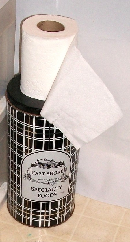 TP tin holder with lid on and extra roll on top.