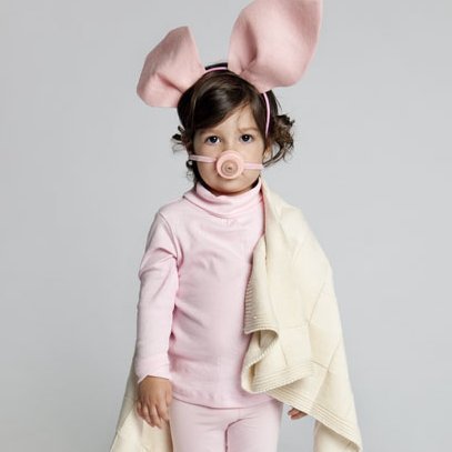 Little girl in a pink pig costume.