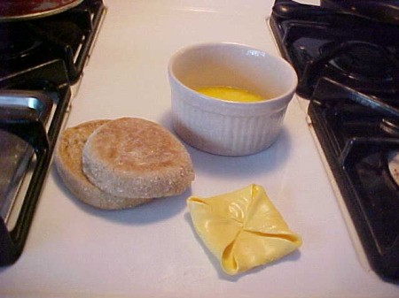 English muffin, cheese folded, and egg in ramekin.