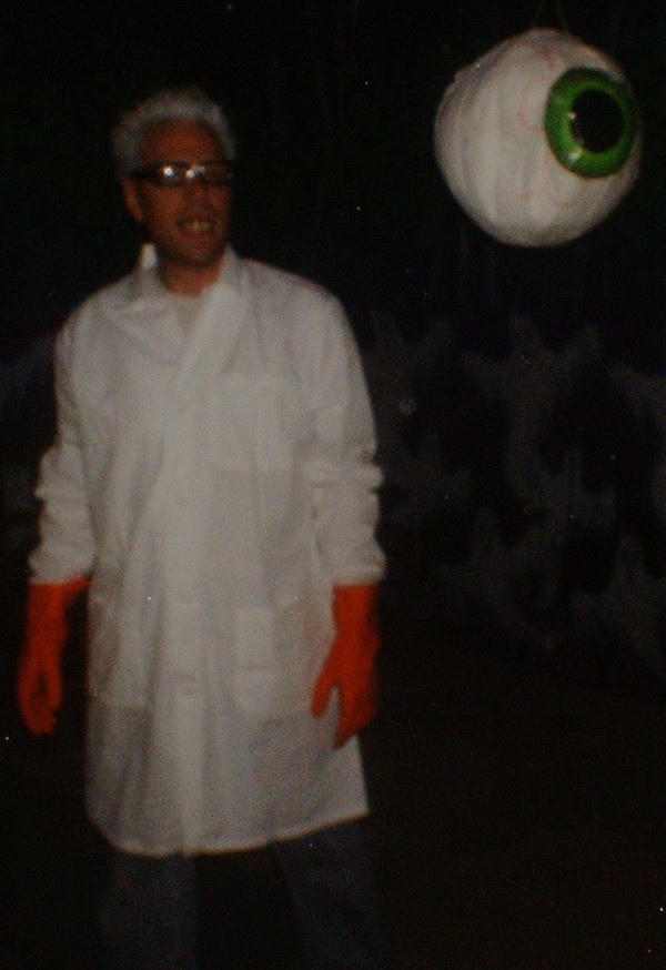 Mad scientist in a dark area with a fake eyeball hanging down.