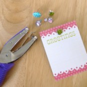 Hole punch, small card, and decorative brads.