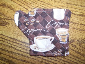 Coffee cup coaster in the shape of a coffee pot.