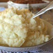 Bowl of mashed potatoes with a spoon handle visible.
