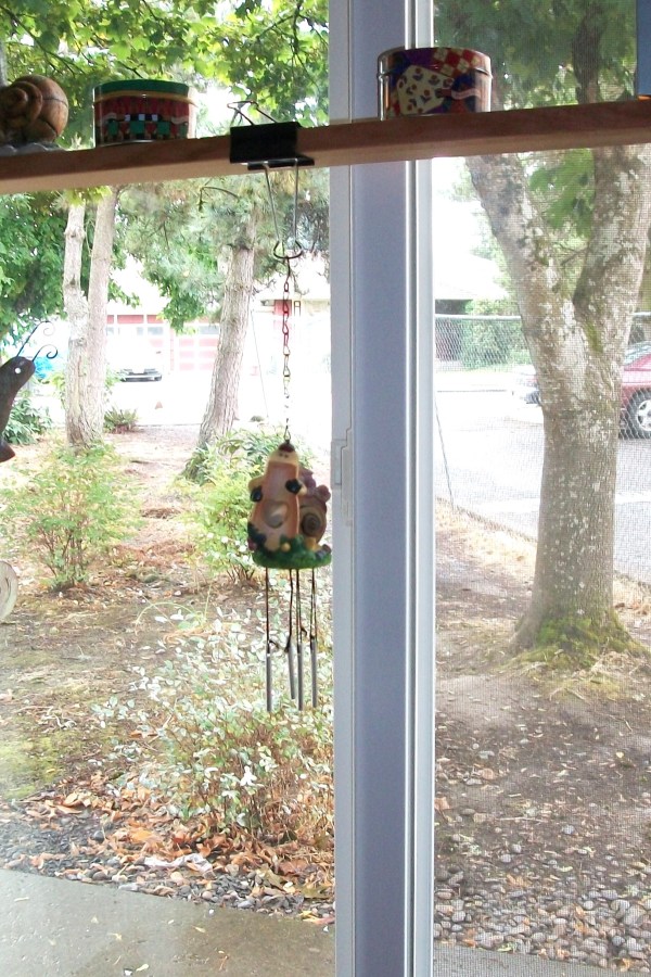 Windchime hanging from a shelf by a binder clip.