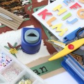 Craft supplies for scrapbooking, including scissors, punches, paper and other decorations.