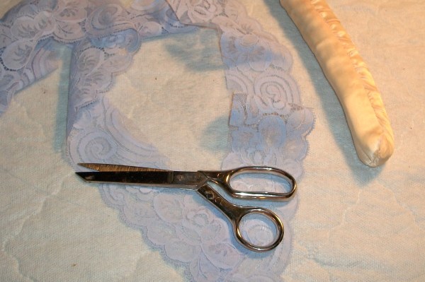 Scissors laying on a strip of lace.