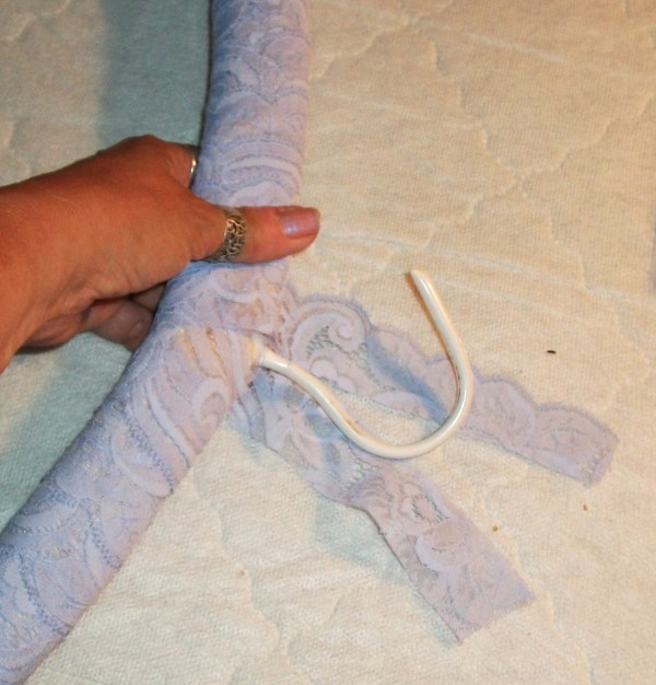 Paaded hanger being laced in light blue lace.