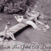 An old black and white photo of people swimming and sunning.