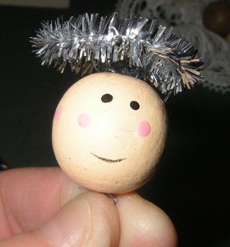 View of bead head with facial features and halo.