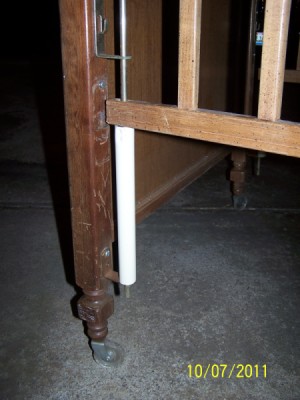 Shows plastc rod holding up crib side.