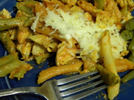 A plate of baked chicken penne with marinara alfredo sauce.