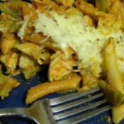 A plate of baked chicken penne with marinara alfredo sauce.