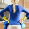 House Cleaning Tips, A woman with cleaning supplies after cleaning her kitchen.