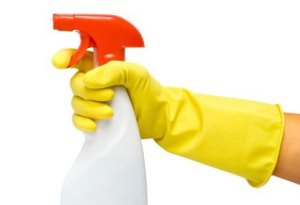 Gloved hand holding a spray bottle.
