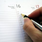 Picture of someone writing in a day planner.