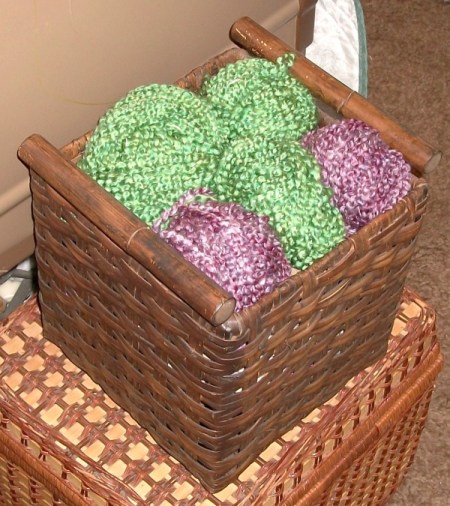 Finished basket storage, with balls of green and purple yarn artfully arranged on top.