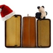 Photo of a suitcase packed for the holidays with a Santa hat on it.