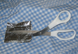 Picture of sharpening scissors with aluminum foil.