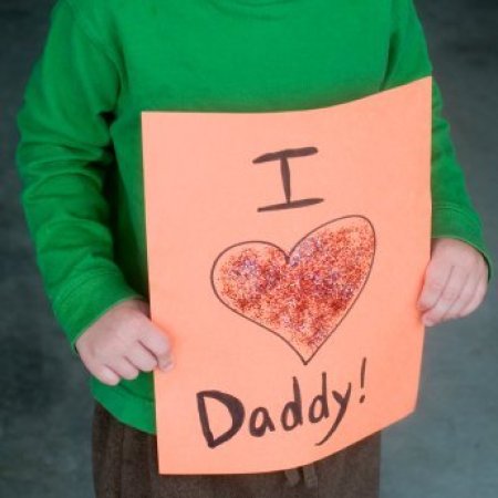 Homemade Father's Day Gifts, A child holding a homemade card that says "I love Daddy".