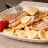 Pancakes with sliced bananas and powdered sugar.