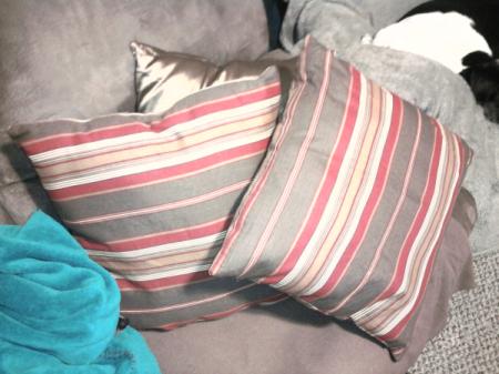 Gray, cream, and pink striped throw pillows.