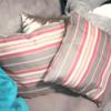 Gray, cream, and pink striped throw pillows.