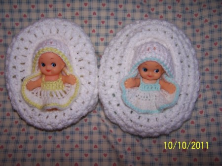 Two baby cradle church purses with Kewpie dolls inside.