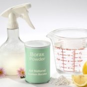 Borax powder, with a measuring cup and spray bottle.