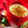 Eggnog Recipes, Eggnog in a festive red cup with small ornaments on the saucer.